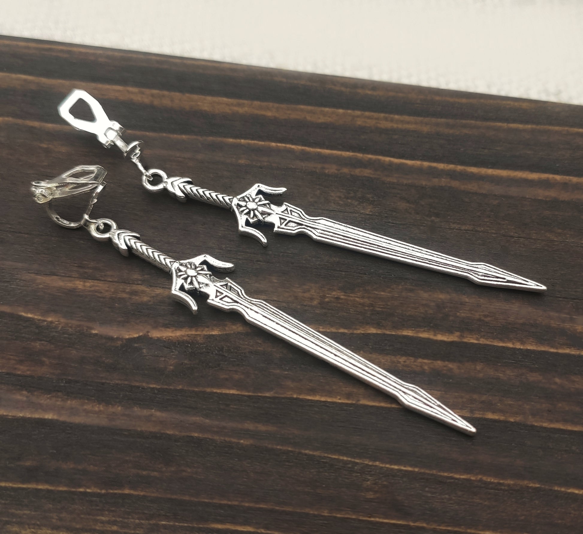 Cosplay-ready silver sword earrings with fantasy and LARP aesthetics. The long sword earrings have stainless steel clip ons.