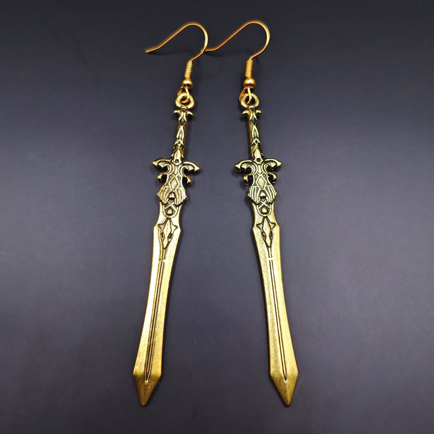Gold sword earrings with fantasy design. A unique gift for RPG players, LARP fans, or gamers.