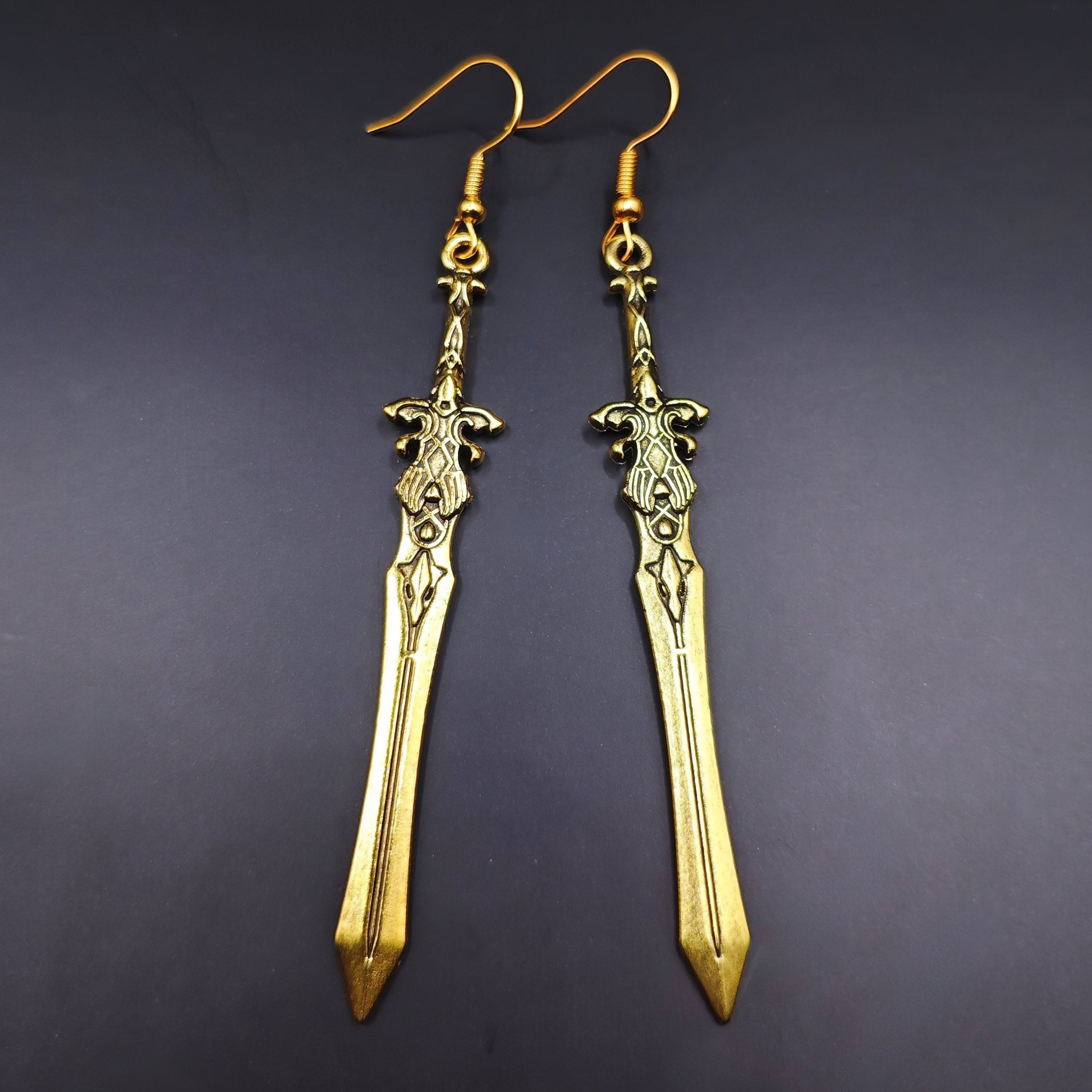 Gold sword earrings with fantasy design. A unique gift for RPG players, LARP fans, or gamers.