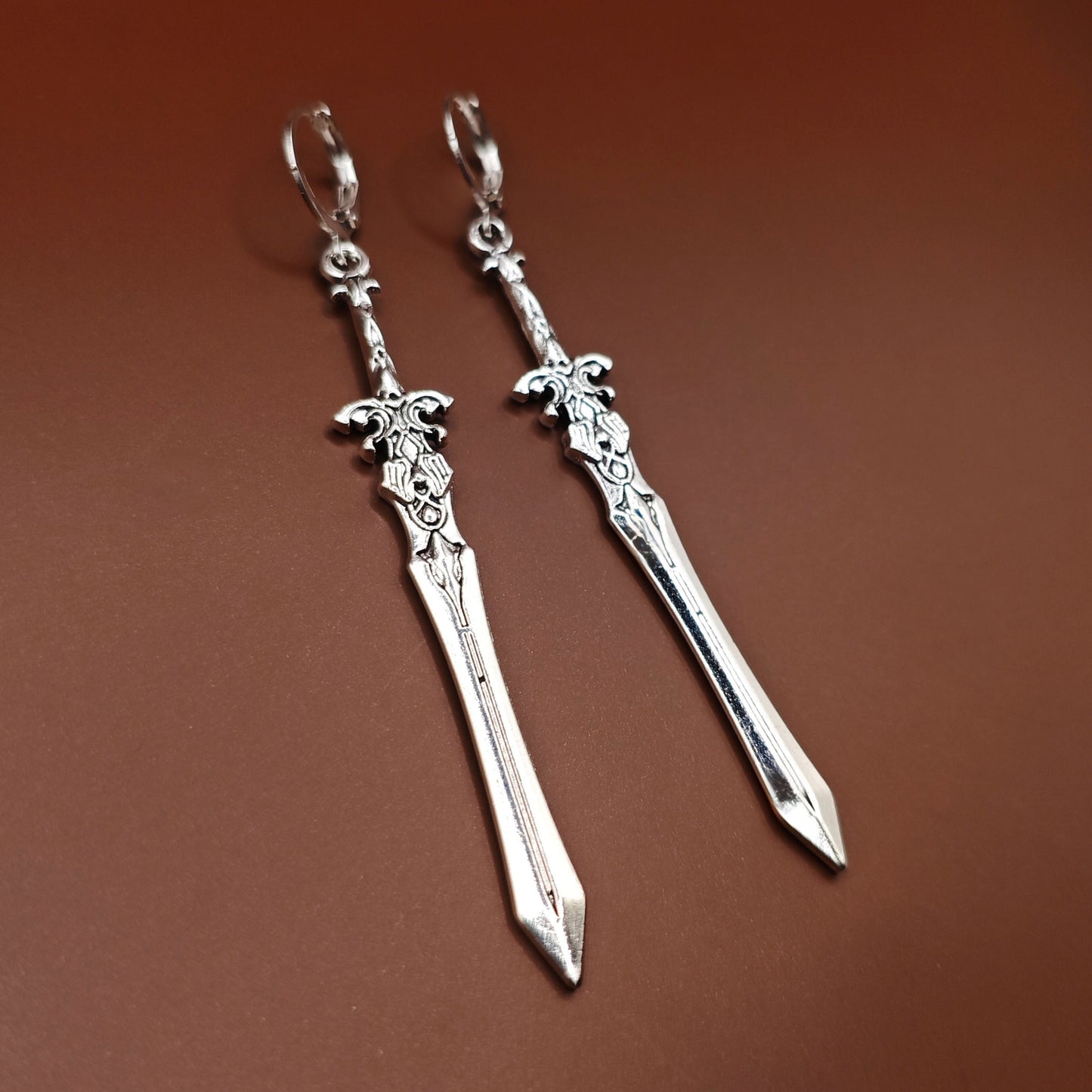 Silver sword earrings with hoops. They have a fantasy viking design – a unique gift for RPG players, LARP fans, or gamers.