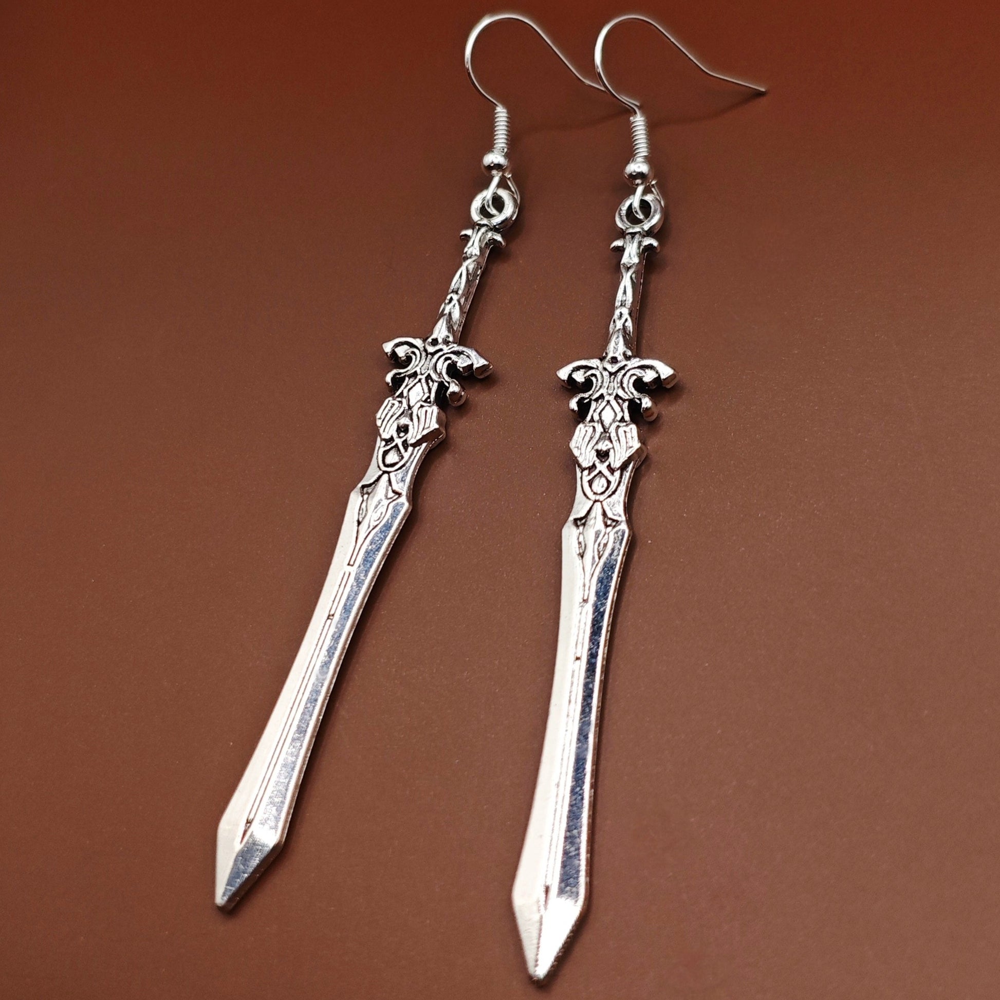 Long silver sword earrings with stainless steel hooks. The swords have a medieval style and would make a great gift for fantasy lovers, those that like larp and rpg, or gamers.