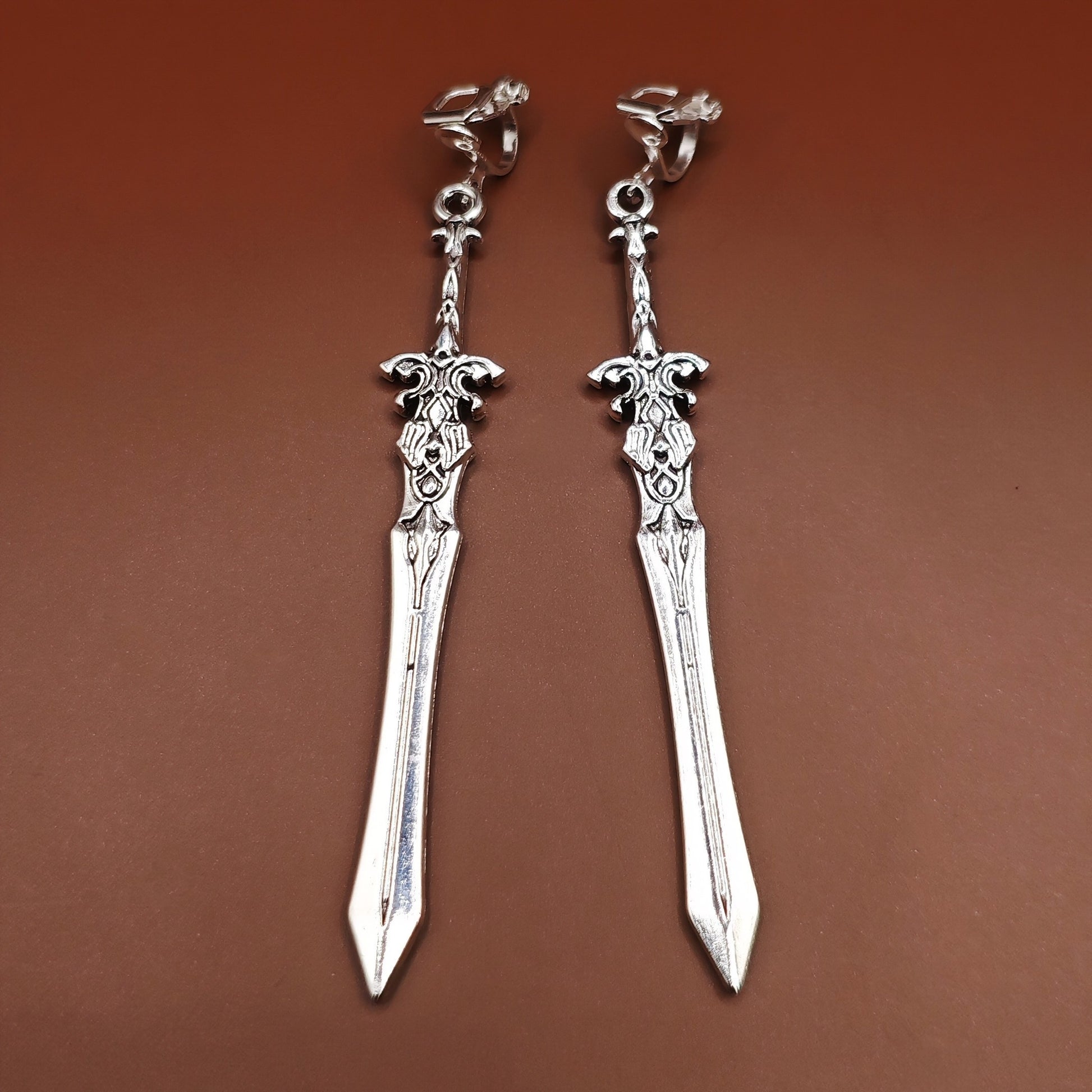 Medieval-style silver sword earrings with stainless steel clip-ons for unpierced ears, perfect for larp, fantasy gaming and cosplay.