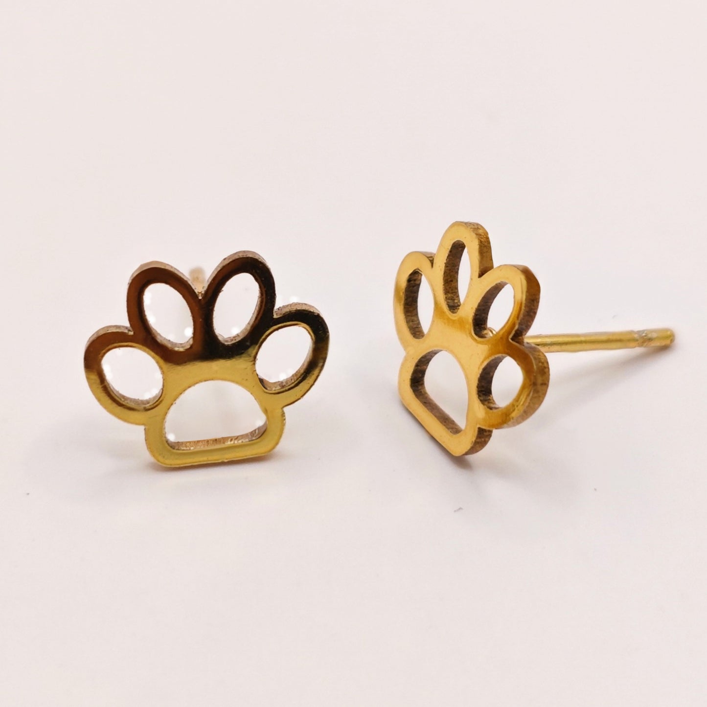 Gold paw print earrings on a white background. A great gift idea for dog lovers and girls.