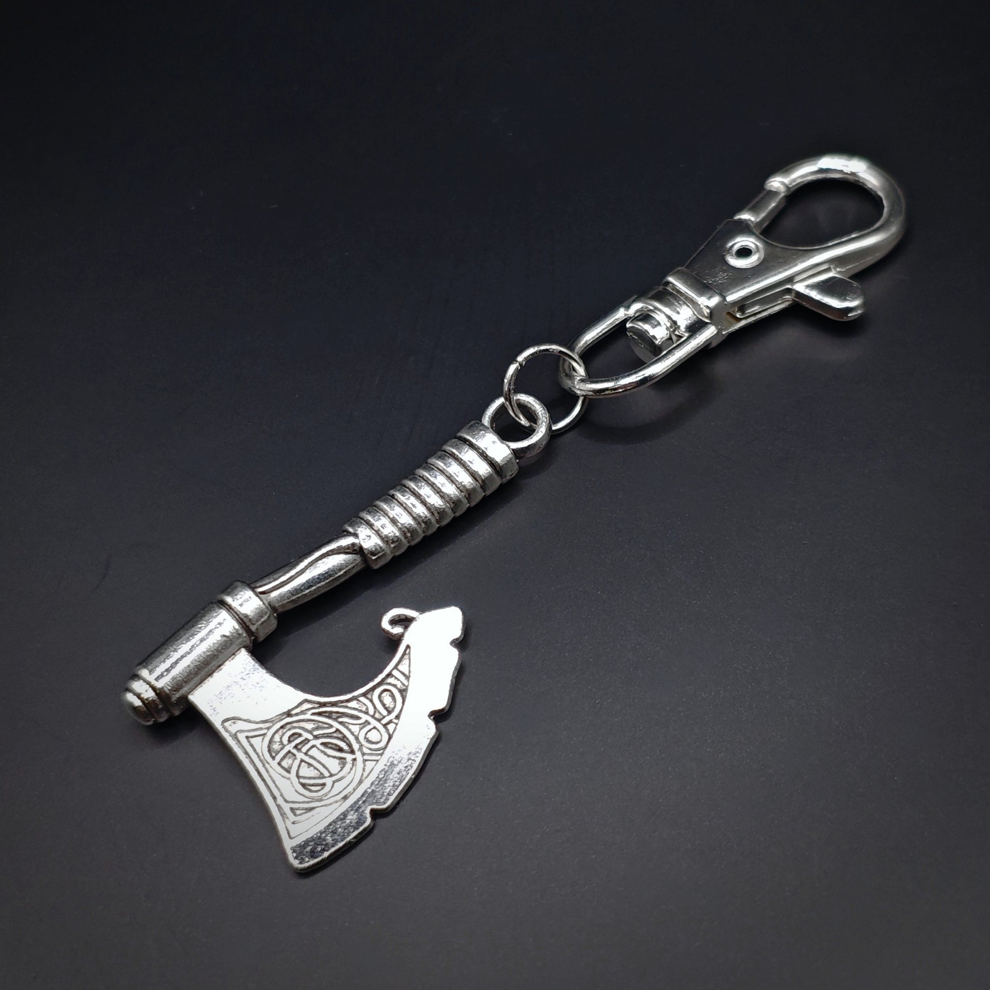 Silver keychain with viking axe design and lobster clasp on a dark background
