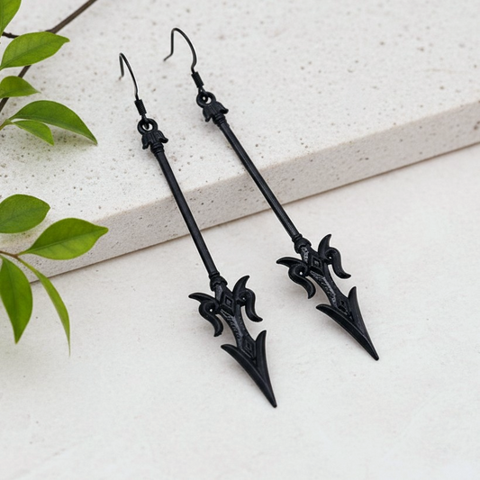 long black mace or axe earrings on a stone background