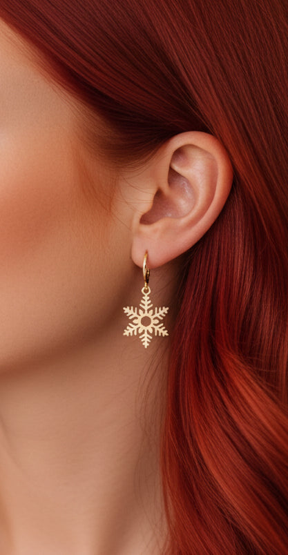 Gold snowflake hoop earring worn by a person with red hair
