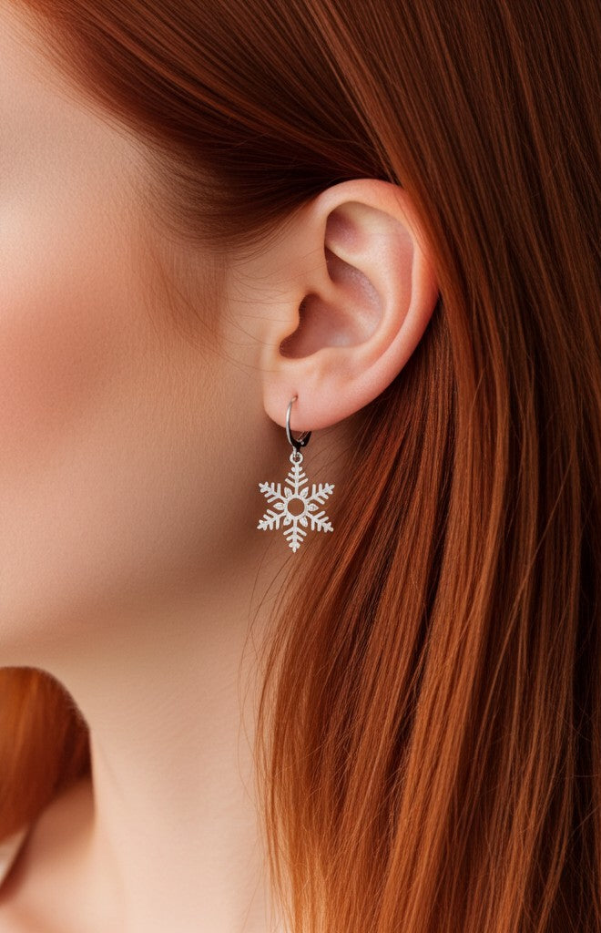 Silver snowflake earring worn by a person with red hair