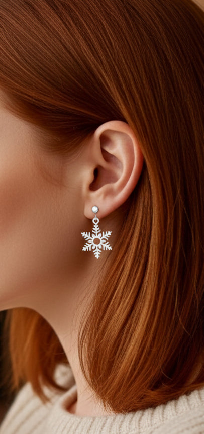 Close-up of a person wearing a clip on snowflake earring with red hair.