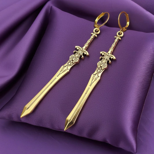 Fantasy gold sword earrings with hoops on a purple background