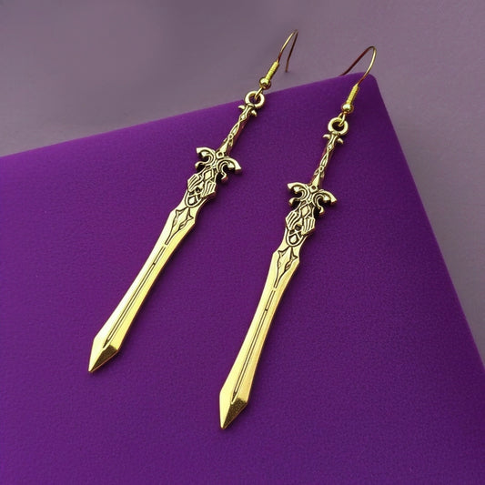 Fantasy gold sword earrings with hooks on a purple background