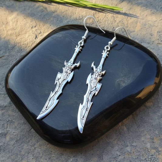 Fantasy silver sword earrings with hooks on a black stone background