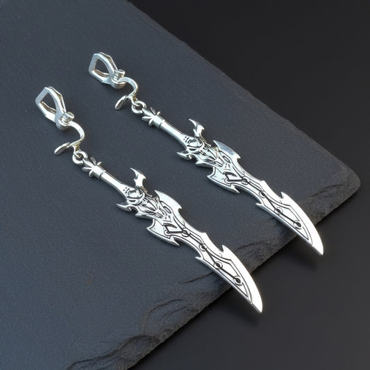 Silver sword earrings with clip on earrings on a black stone background