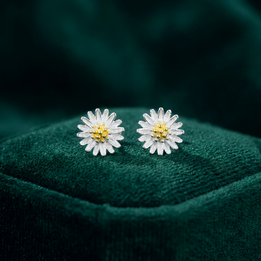 Little daisy silver stud earrings on a green background
