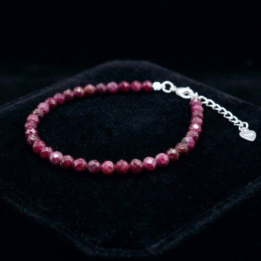 Beaded bracelet with 925 silver clasp with ruby beads on a black background