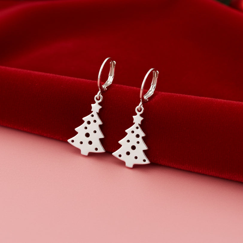 Silver Christmas tree earrings on a red and pink background