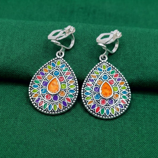Colorful silver mandala boho clip-on earrings on a green background
