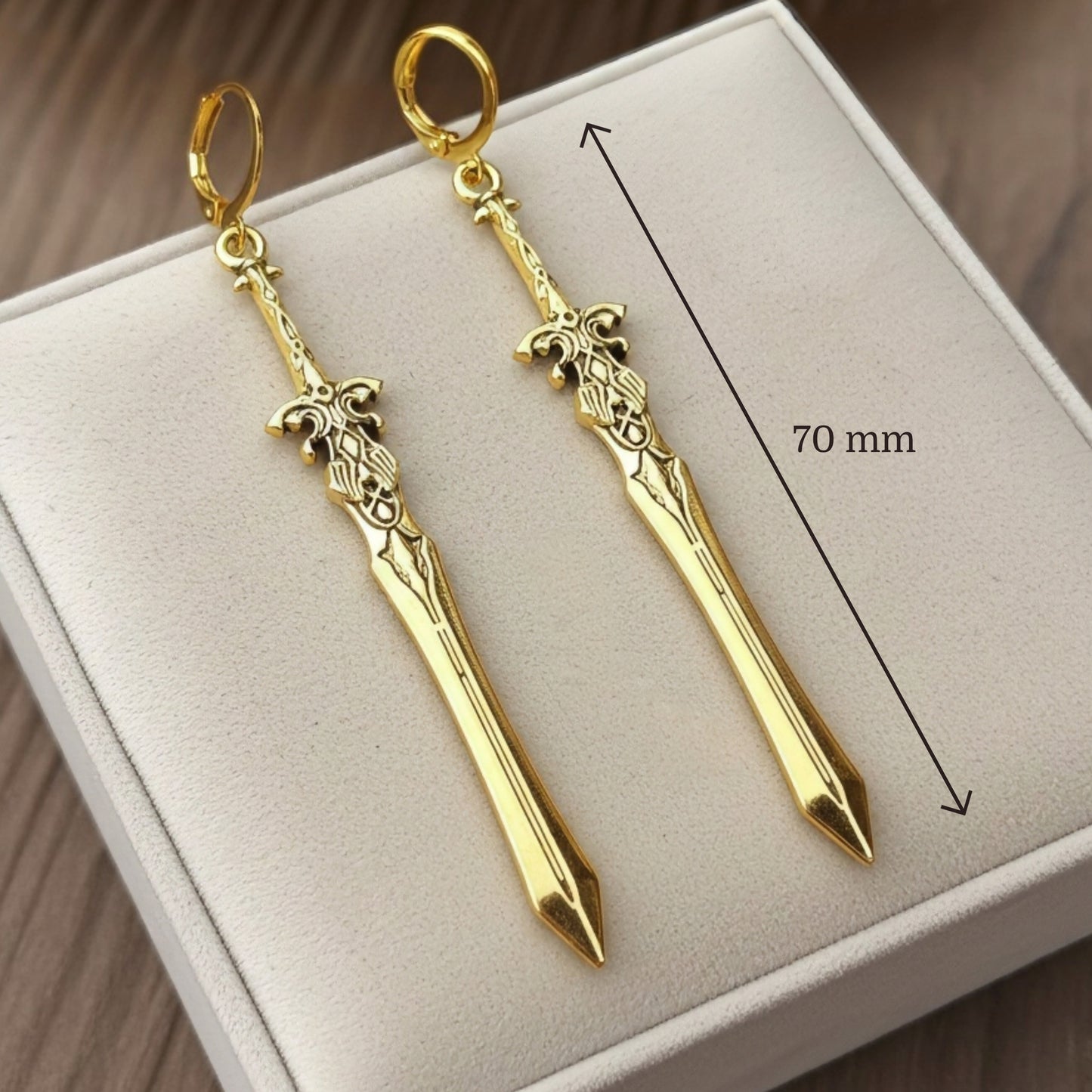 Fantasy gold sword earrings with hoops on a white background with measurements shown