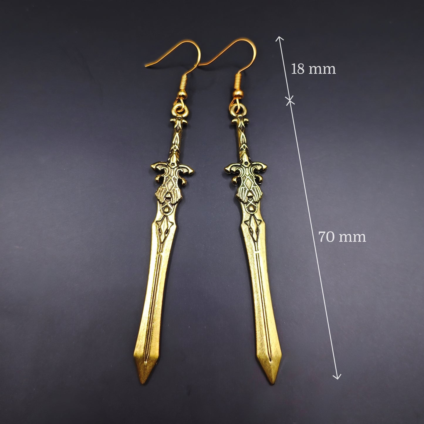 Gold sword earrings with measurements on a black background. Great for cosplay or costumes.