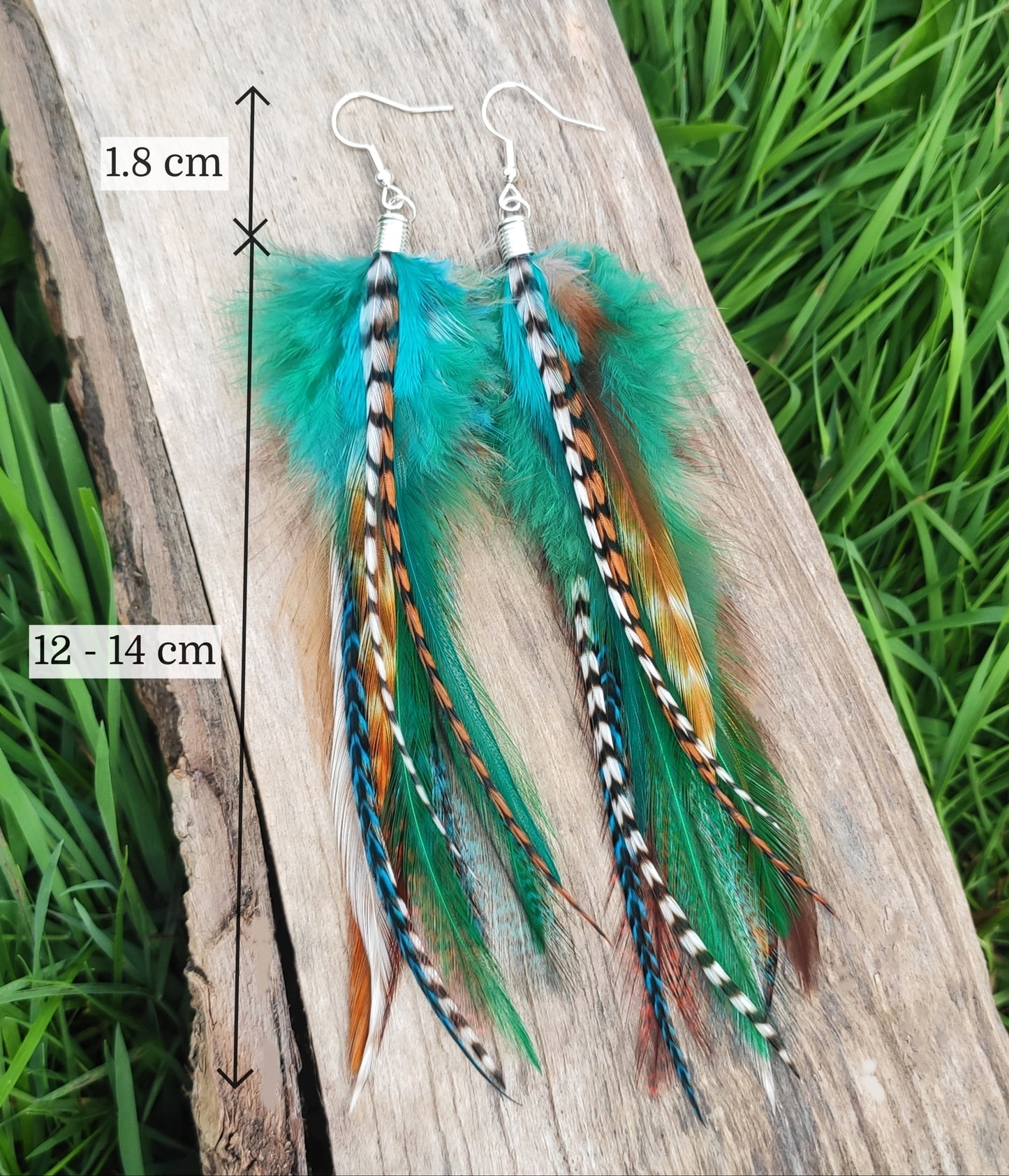 Colorful feather earrings on a wooden surface with measurements indicated