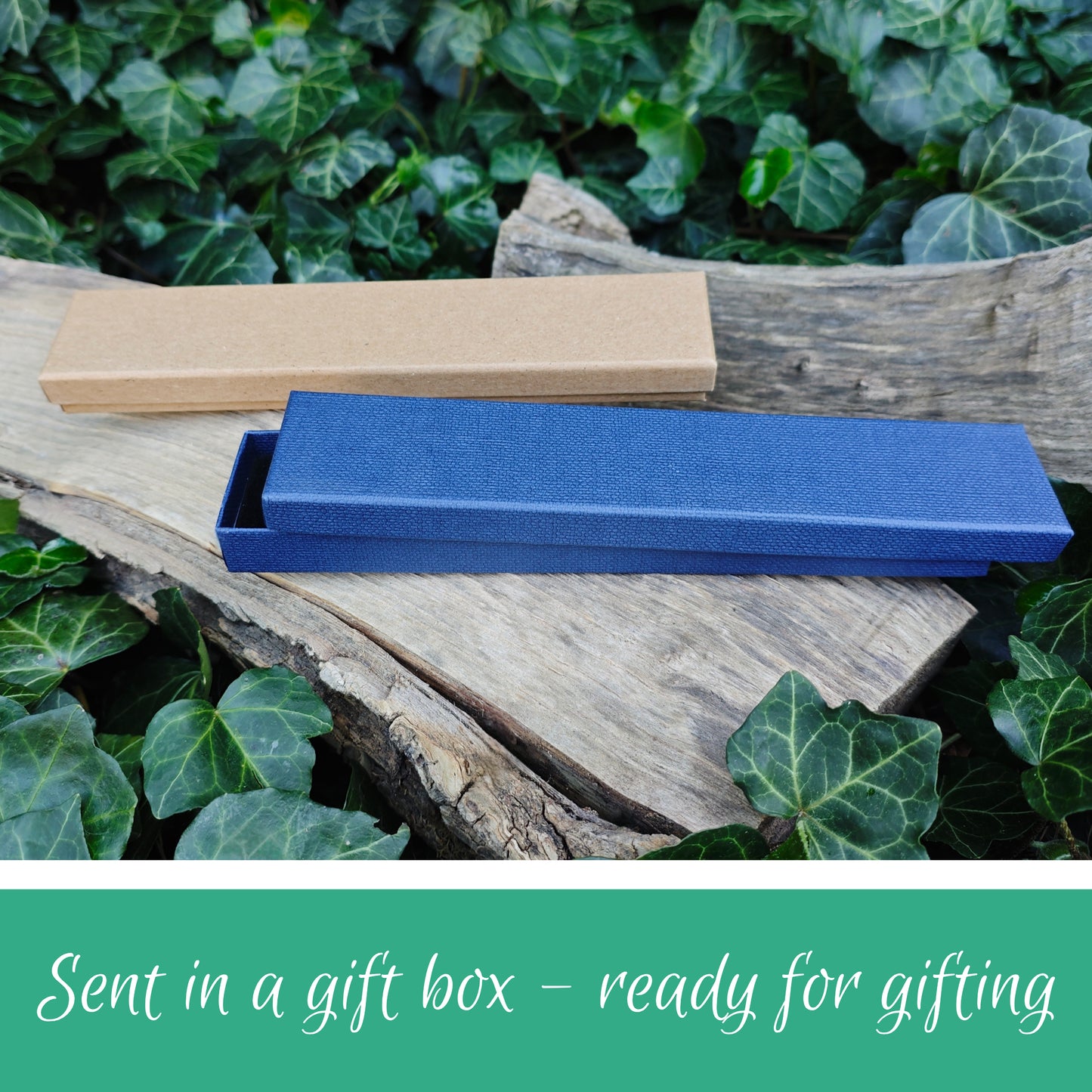 Blue gift box on a wooden surface with green foliage in the background. A message that says sent in a gift box, ready for giving.