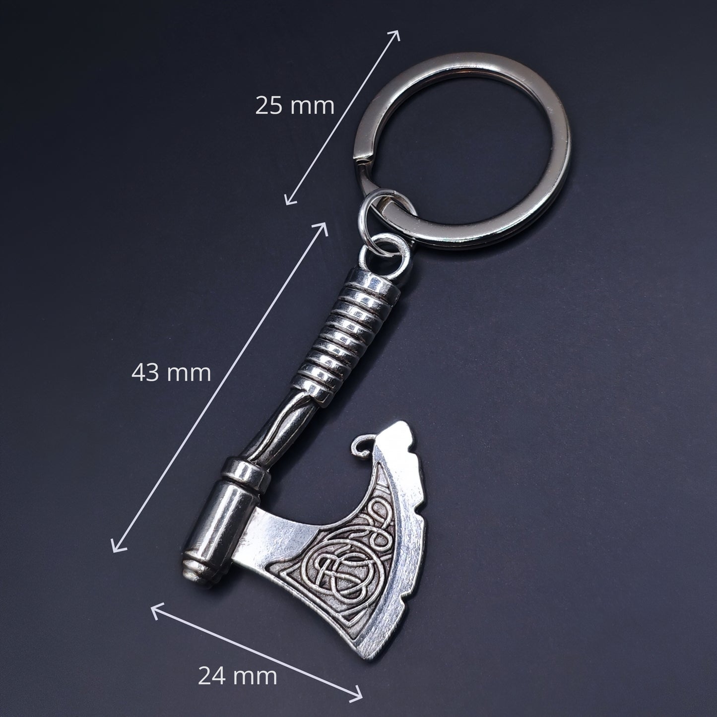 Silver keychain with axe design and measurements on a dark background