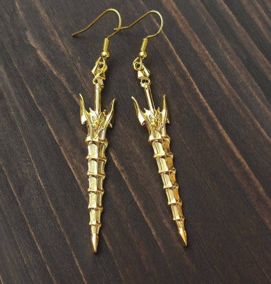 Fantasy style gold sword earrings with hooks on a wooden background