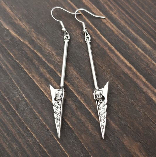 Silver arrowhead shaped sword earrings on a wooden surface. Fantasy mace earrings.