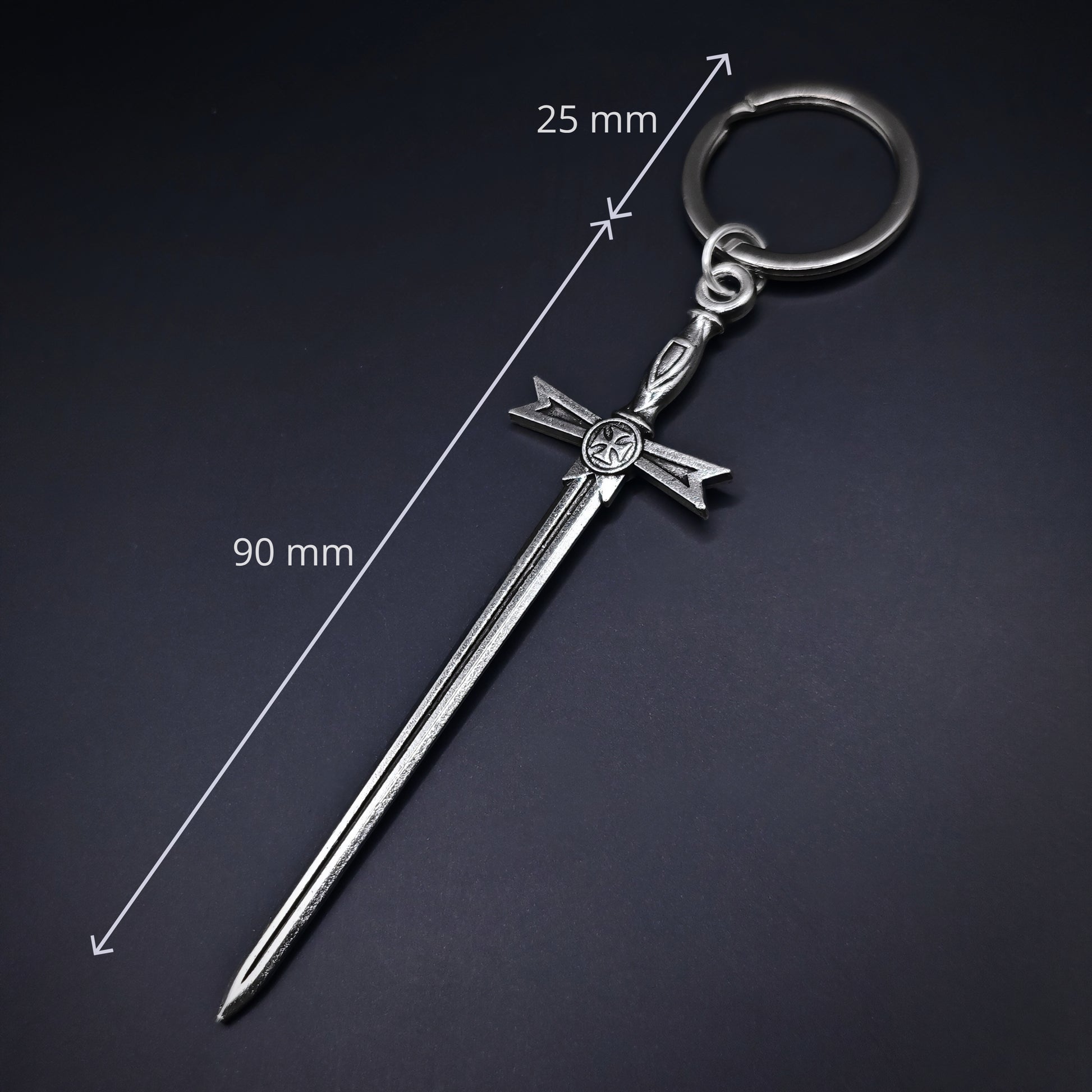 Silver sword-shaped keychain with measurements on a dark background