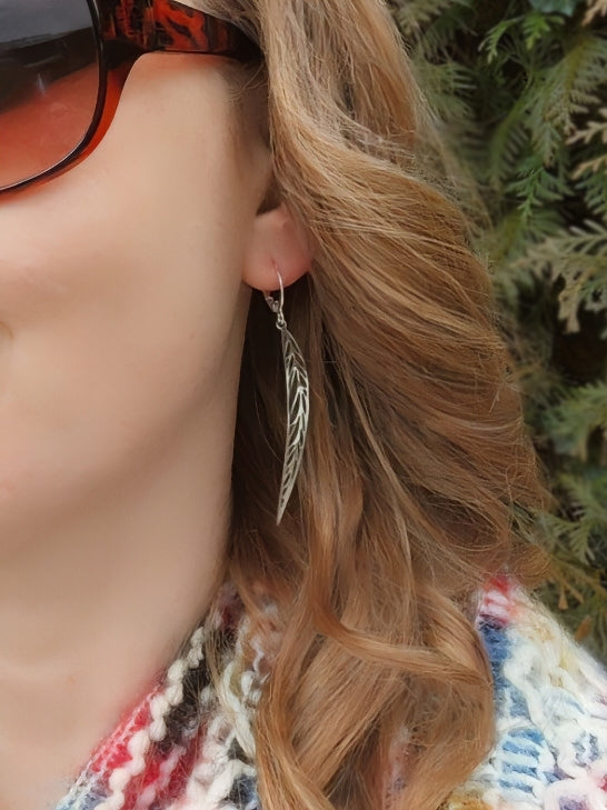 Woman wearing long silver stainless steel leaf earrings 
