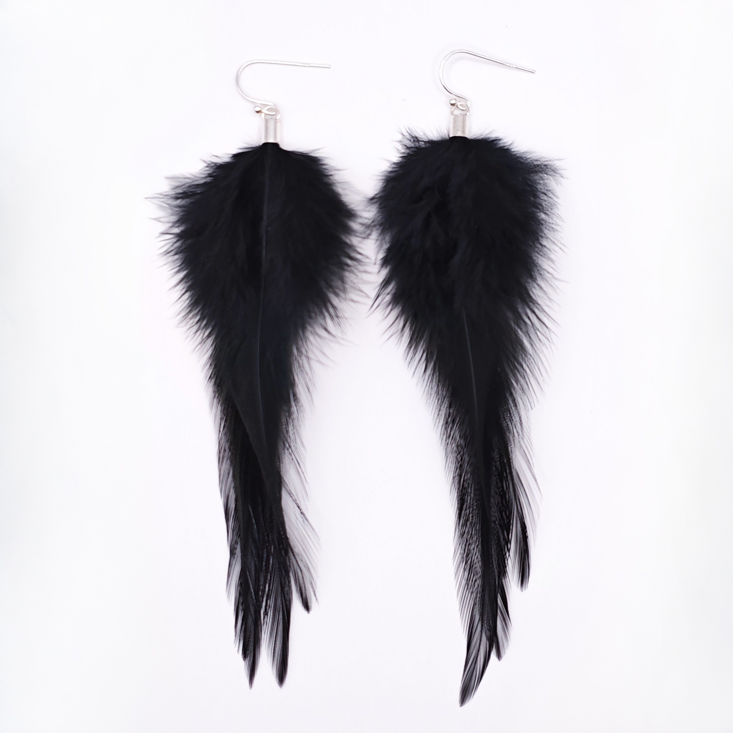 Black feather earrings with silver hooks on a white background. Gothic jewelry