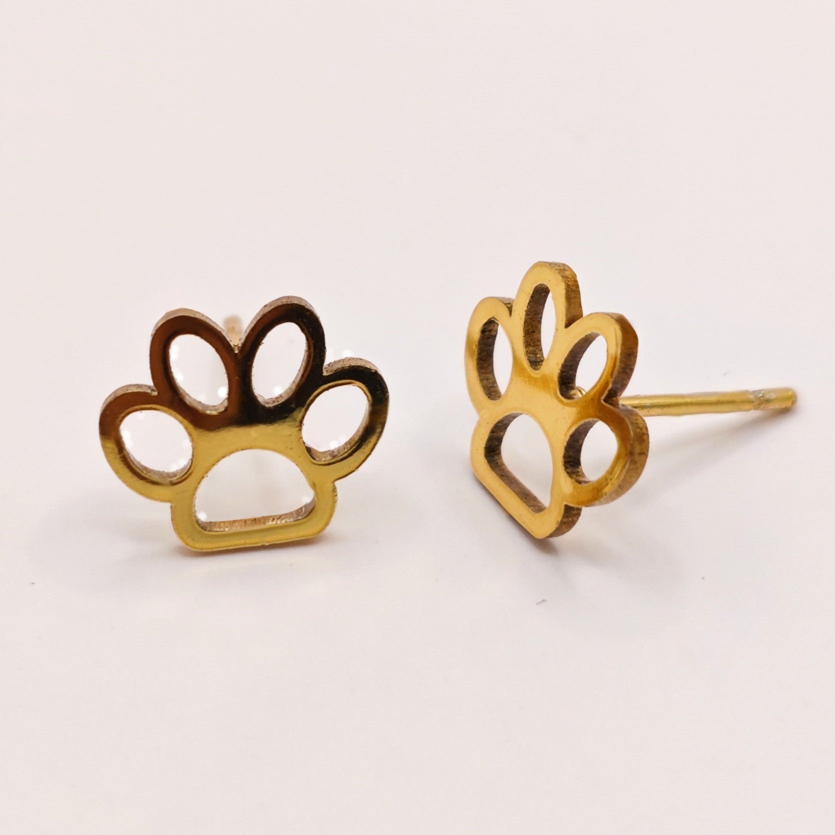 Gold paw print earrings on a white background. A great gift idea for dog lovers and girls.