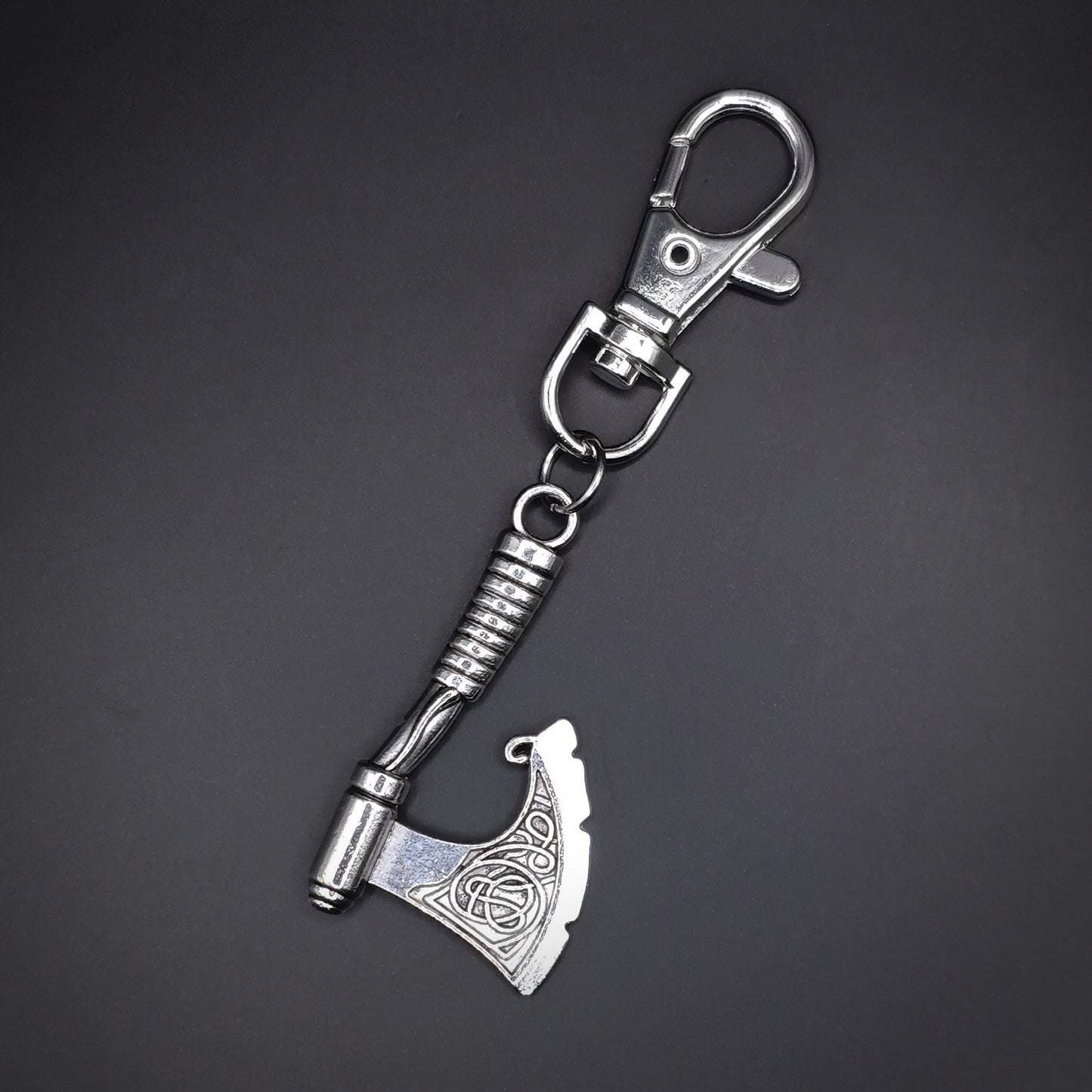 Silver axe-shaped keychain on a dark gray background
