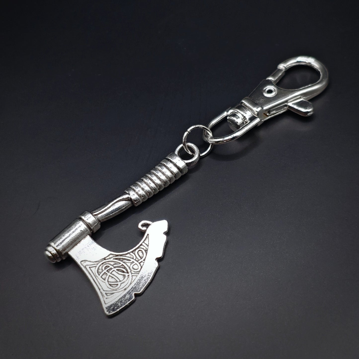 Silver keychain with viking axe design and lobster clasp on a dark background