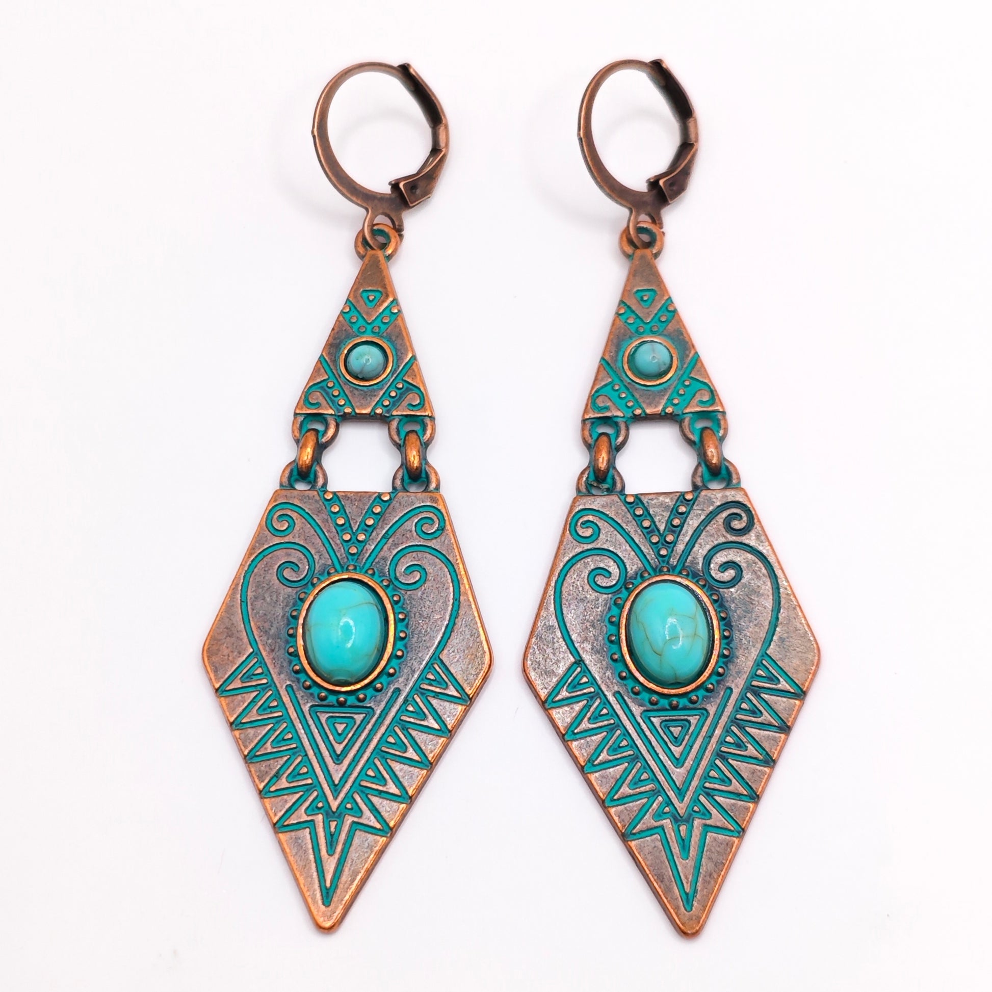 Pair of copper boho dangle earrings with geometric design and turquoise stones on a white background