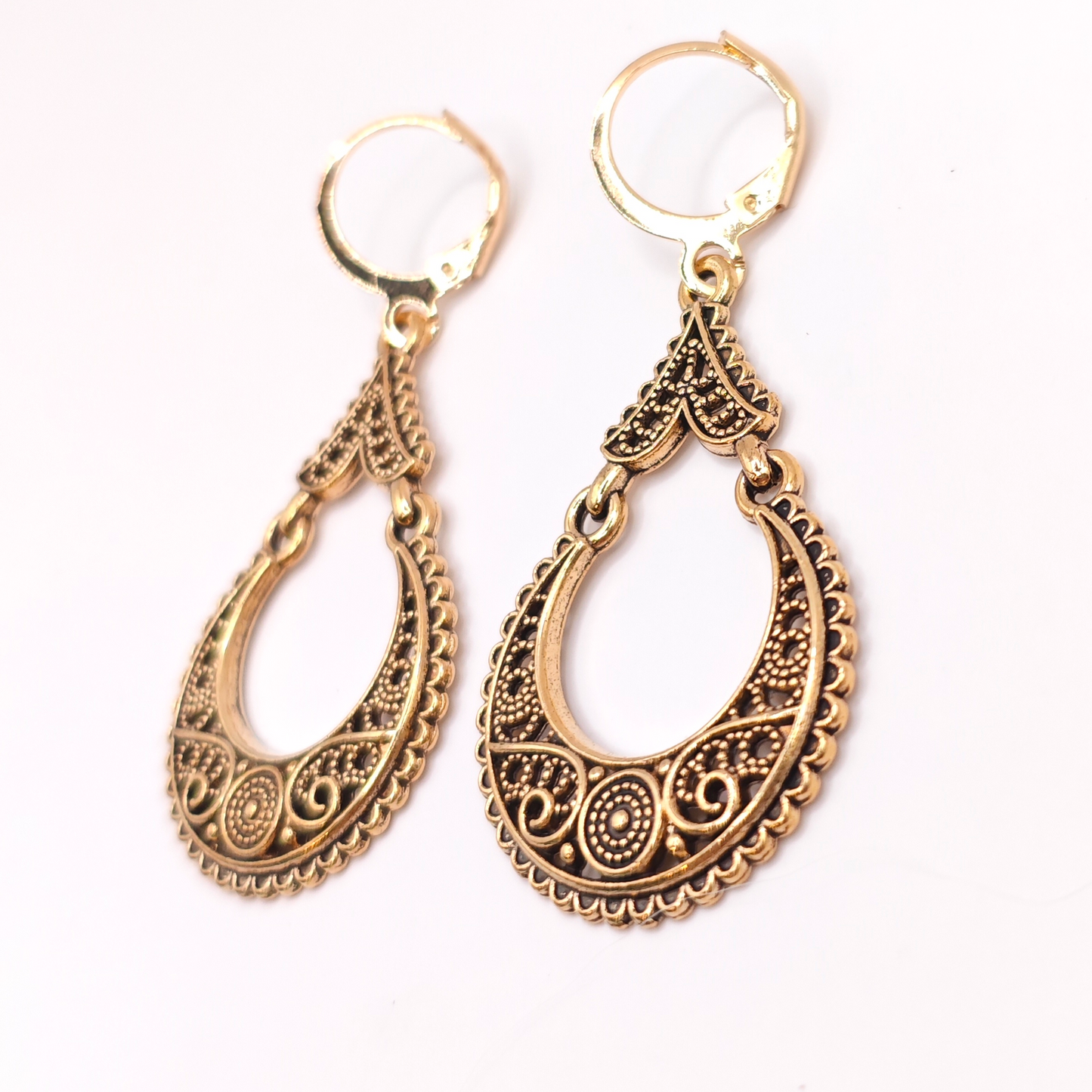 Pair of boho chic gold hoop earrings with intricate designs on a white background