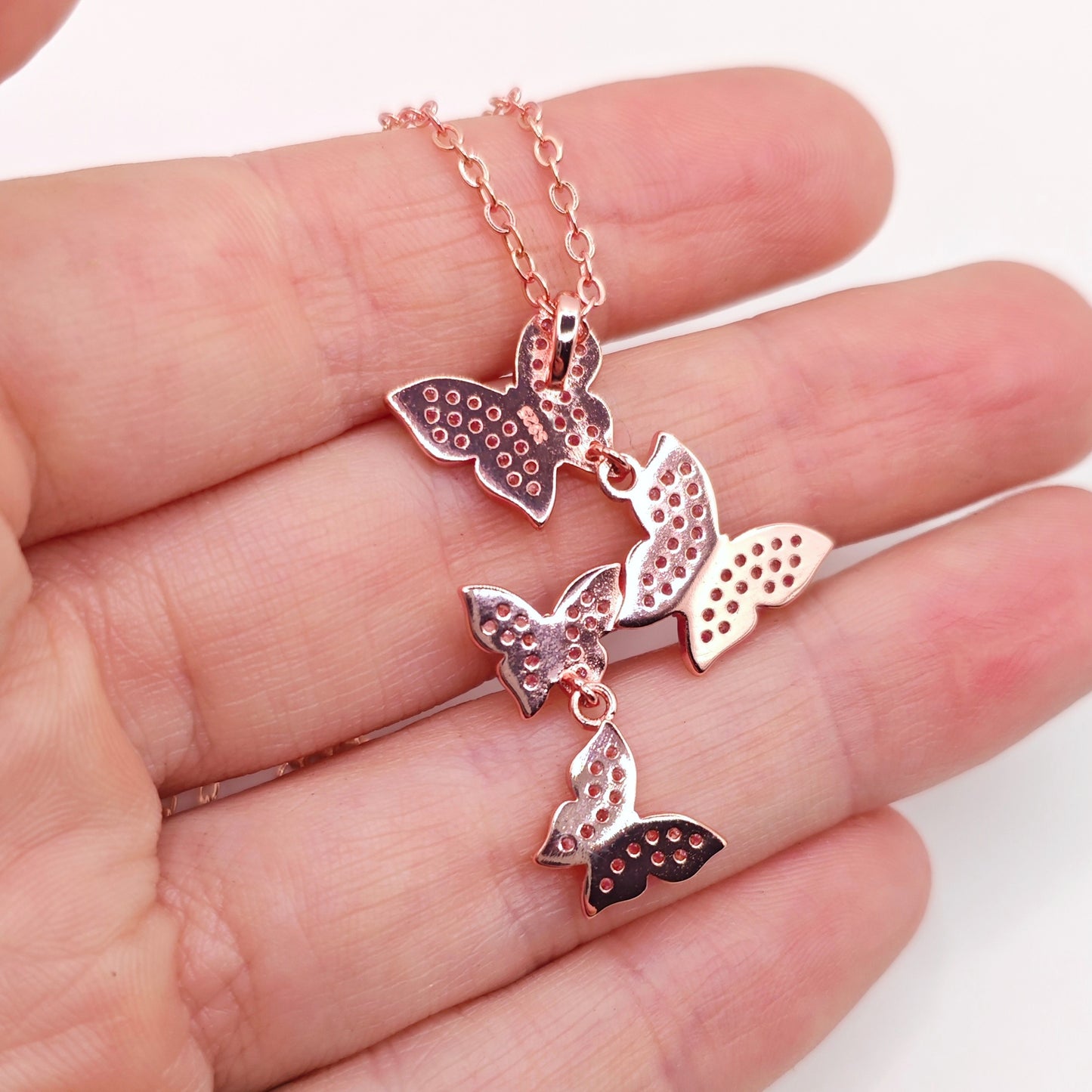 The back of a pink butterfly necklace showing the S925 silver hallmark