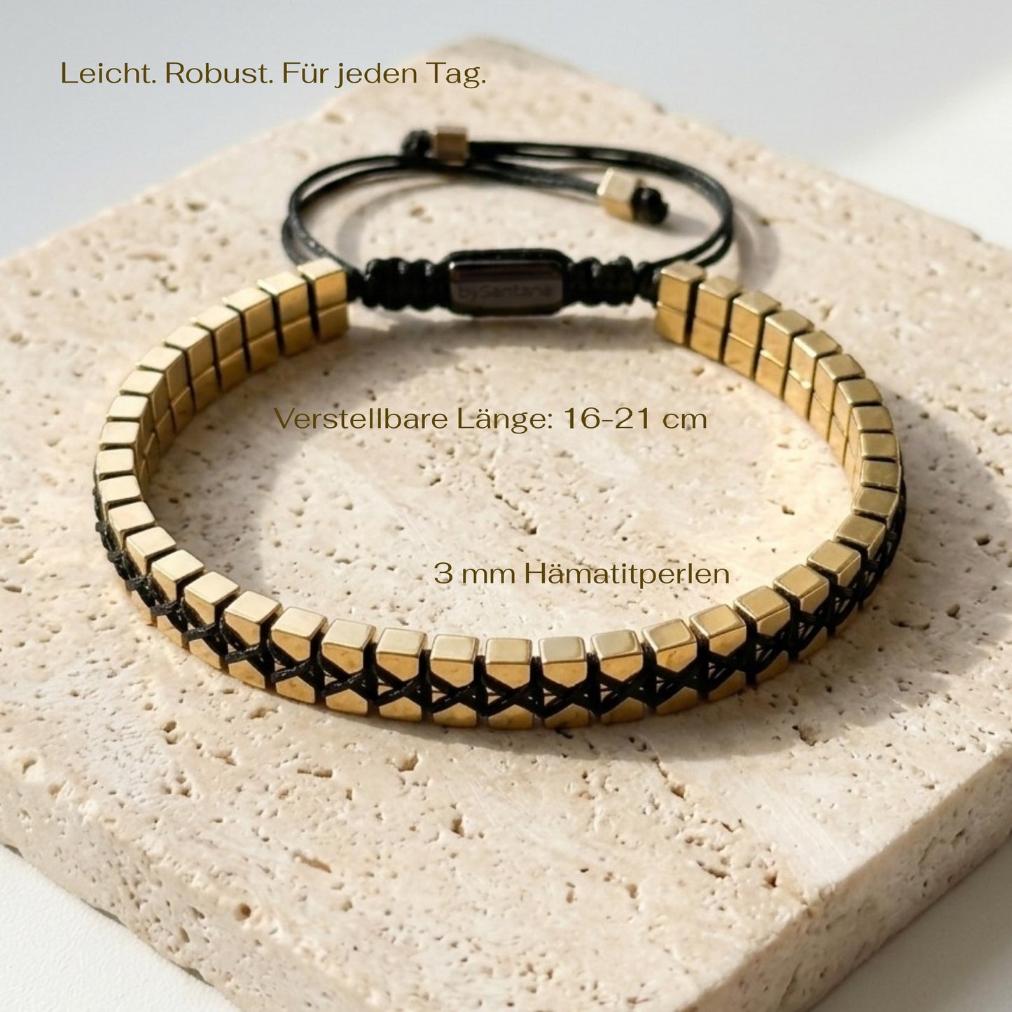 Bracelet with gold and black beads on a textured surface with measurements