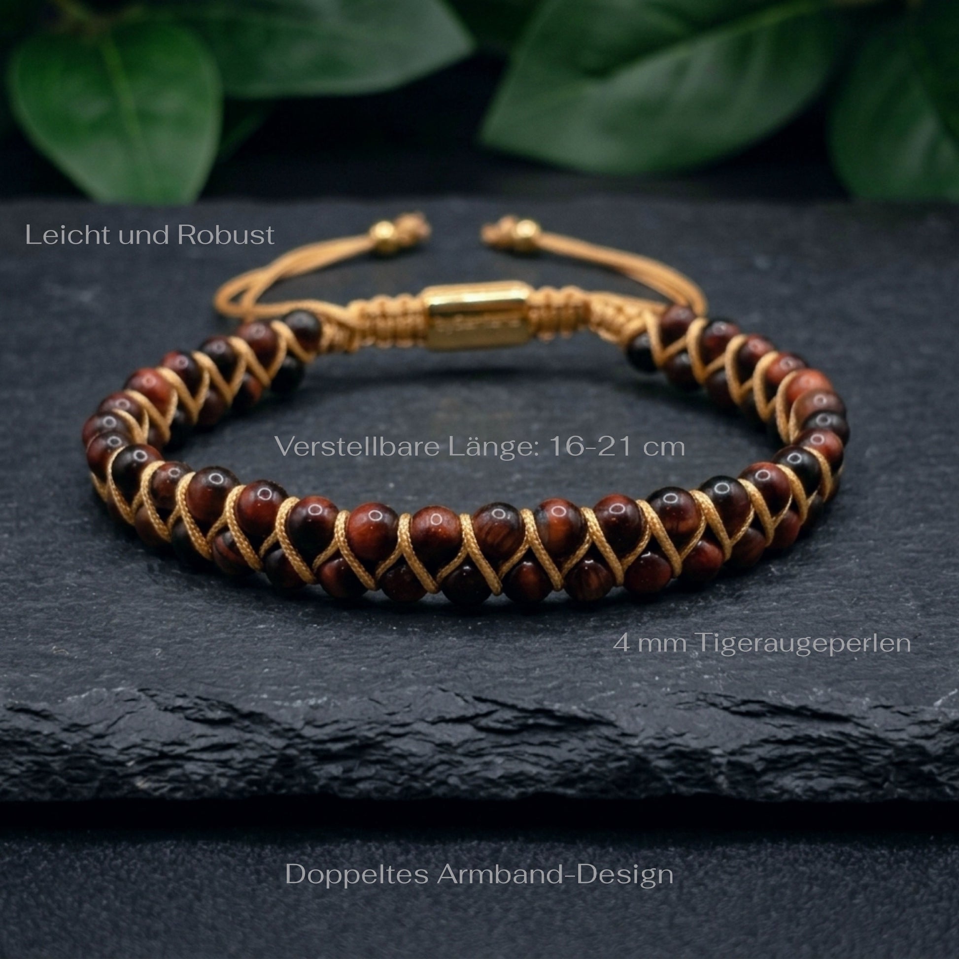 Bracelet with red tiger's eye gemstone beads and gold braided cord on a dark stone surface with green leaves in the background and measurements shown