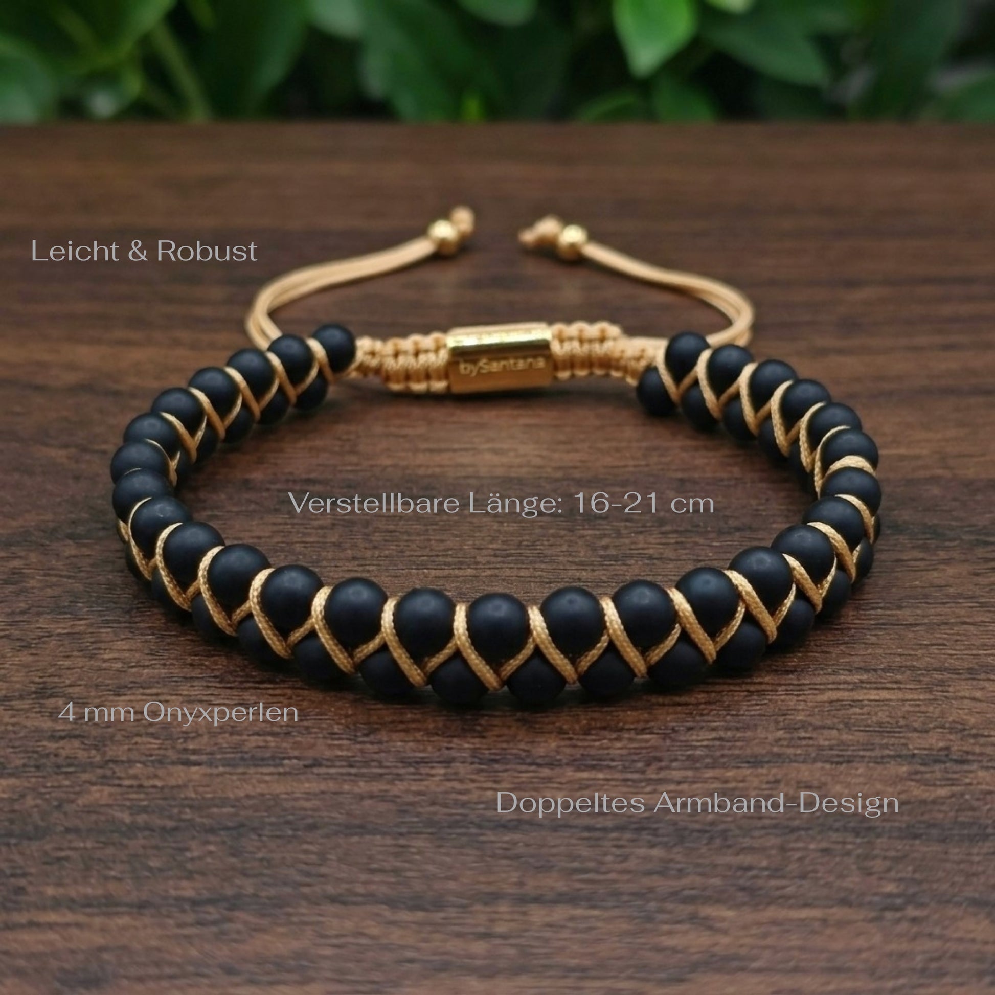 Matt Black Onyx beaded gemstone bracelet with gold accents on a wood surface with green leaves in the background and measurements shown