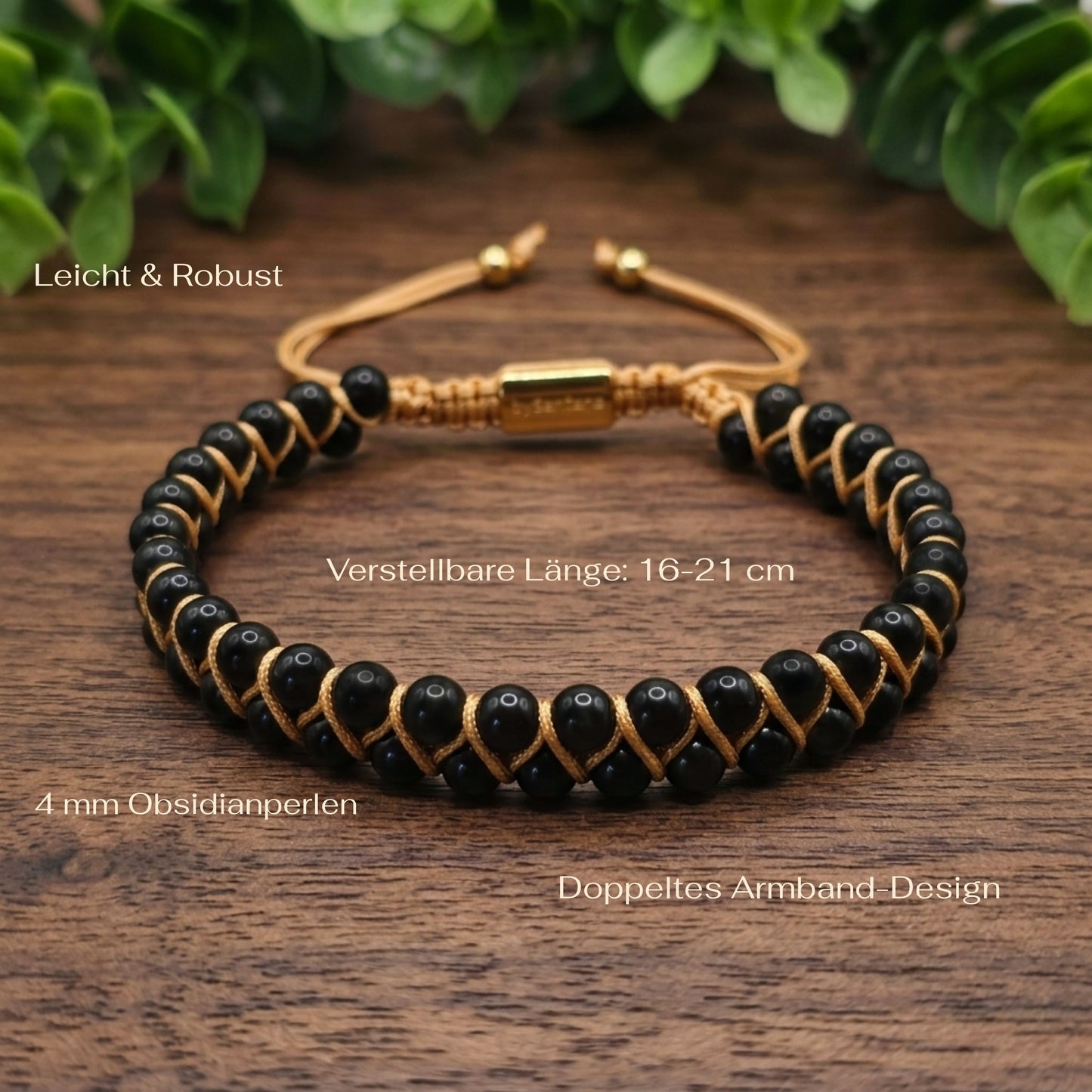 Black obsidian beaded gemstone bracelet with gold accents on a wooden surface with green leaves in the background and measurements shown