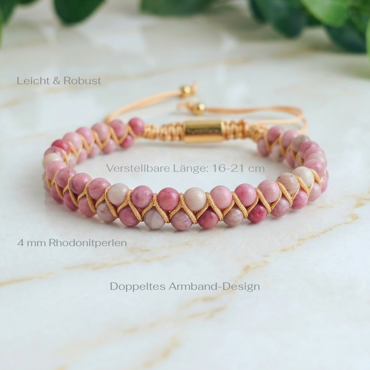 Pink Rhodonite beaded gemstone bracelet woven with gold accents on a marble surface with measurements
