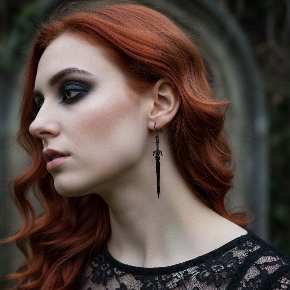 A gothic woman with red hair wearing long black sword earrings