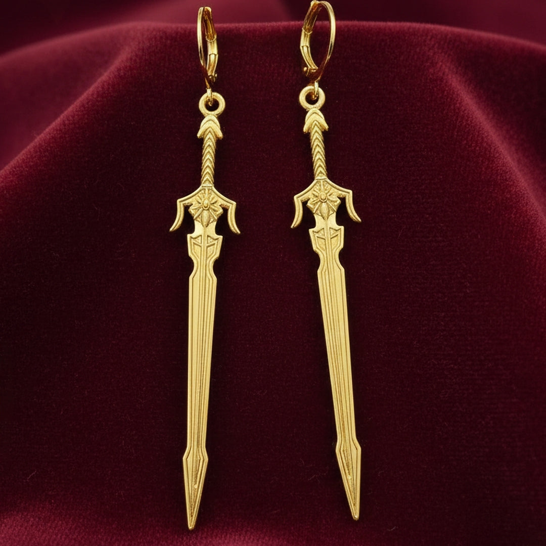 Medieval style fantasy long gold sword earrings with leverback hoops on a red background
