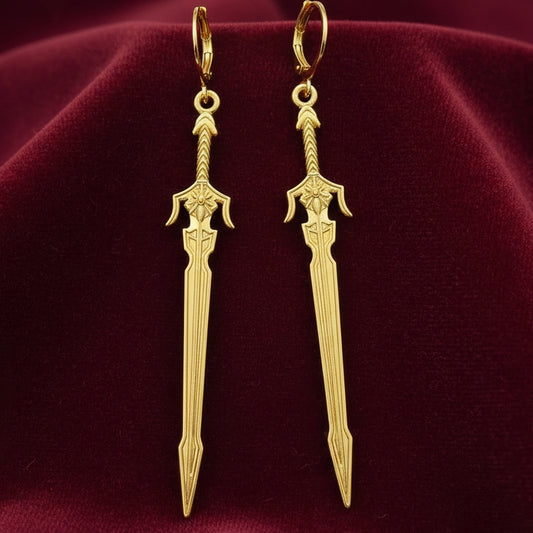Medieval style fantasy long gold sword earrings with leverback hoops on a red background