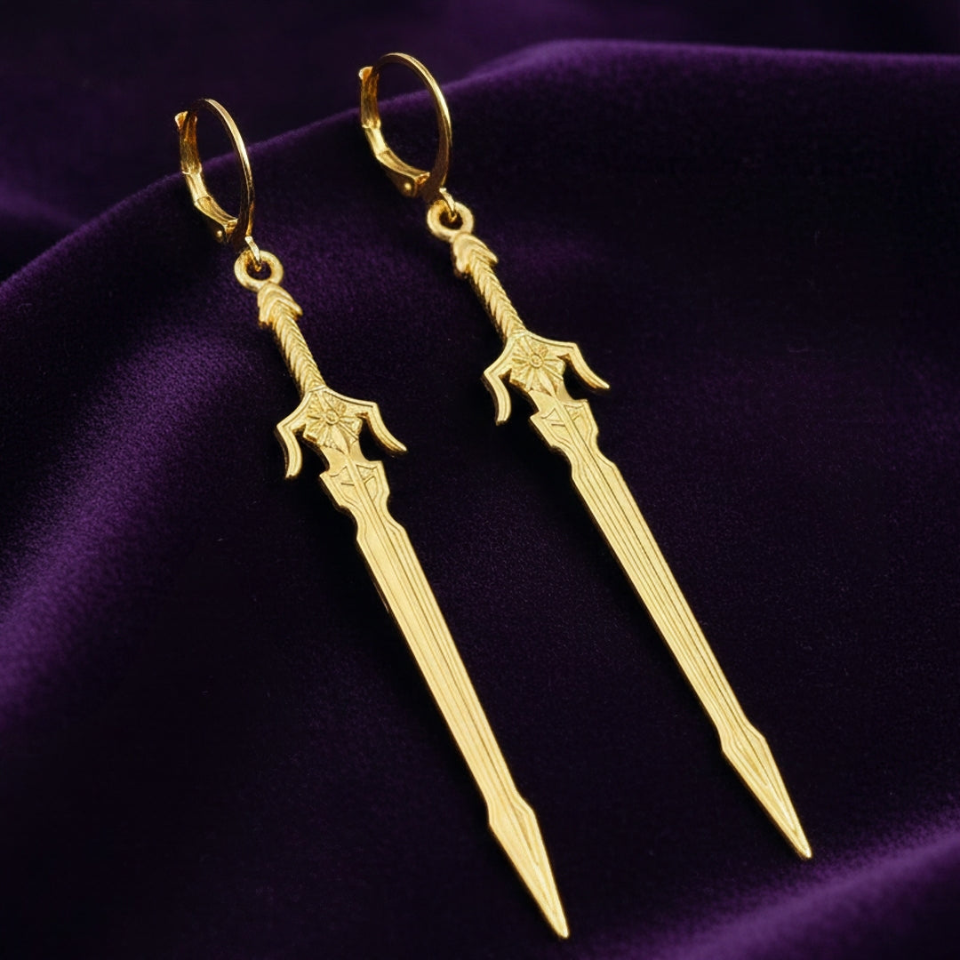 Medieval style fantasy long gold sword earrings with leverback hoops on a purple background
