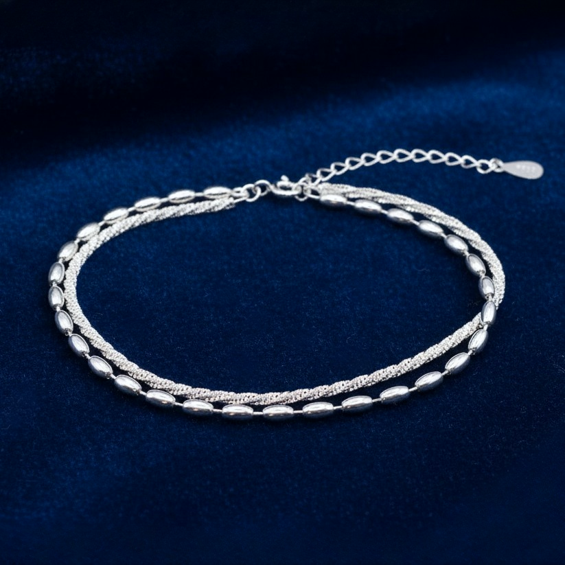 925 Silver Bracelet featuring a double chain, one twisted sparkle chain and one with oval beads, on a blue background