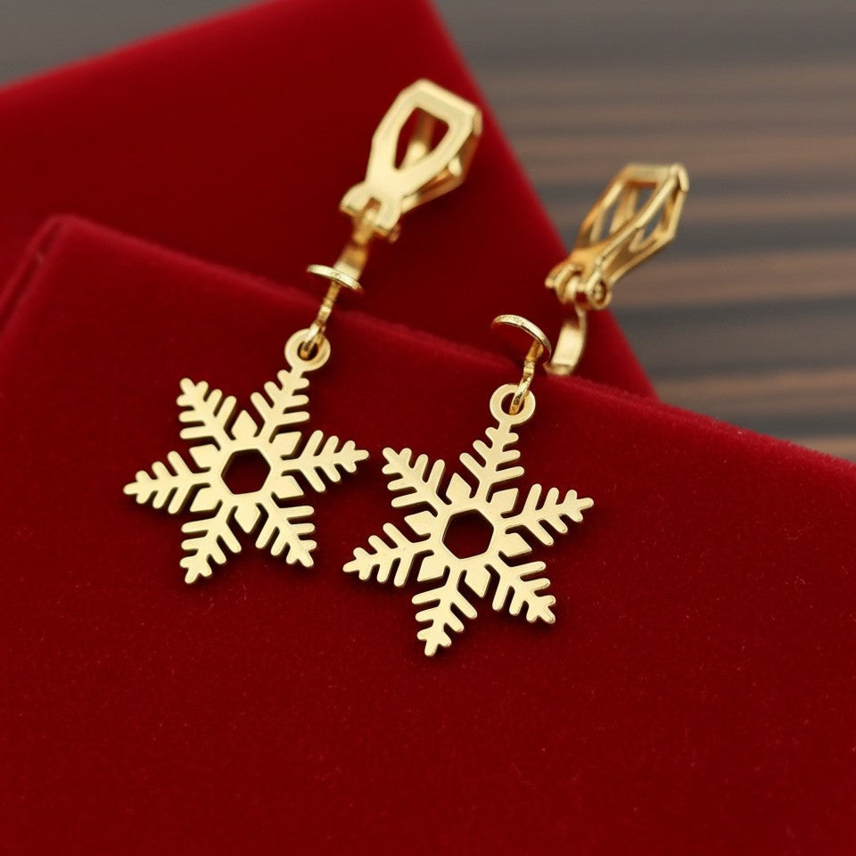 Gold snowflake earrings with clip ons on a red velvet background