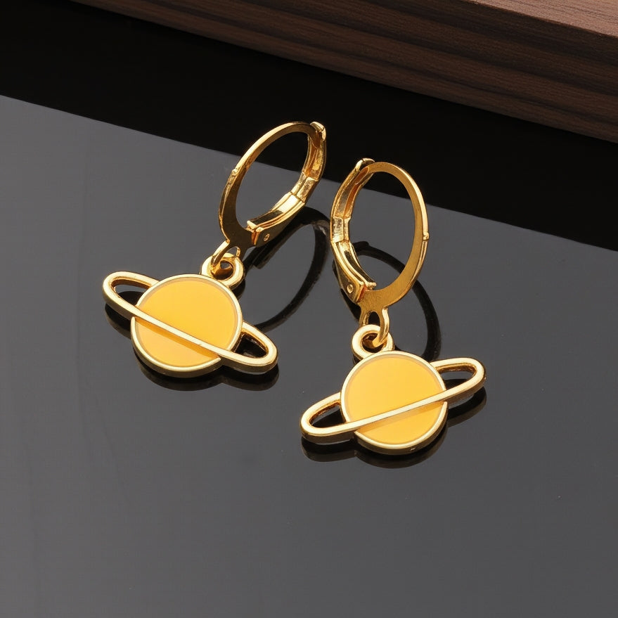 Yellow Saturn planet earrings with gold hoops on a black background
