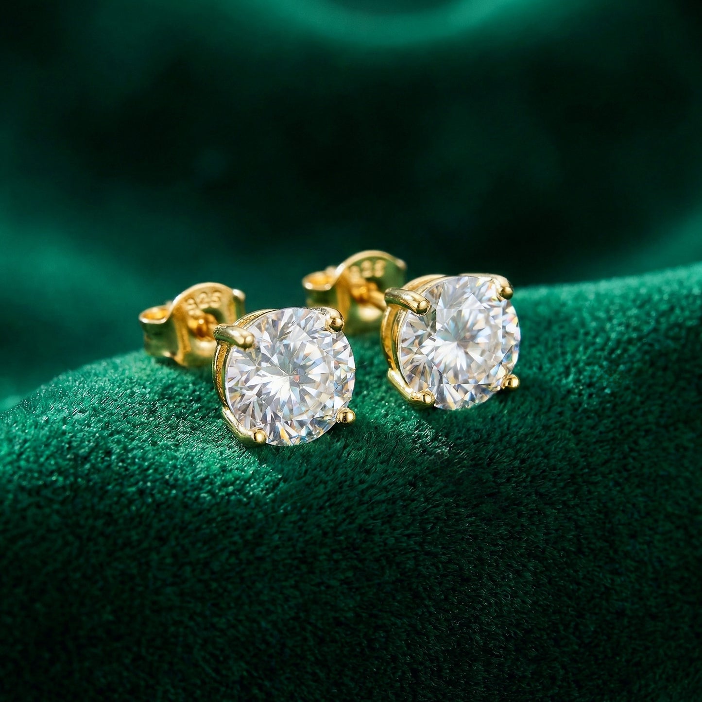 Sparkly gold 925 silver stud earrings with white cubic zirconia crystals on a green background
