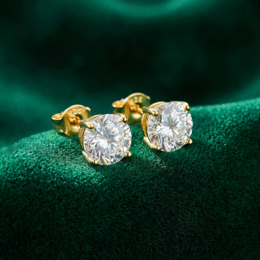 Sparkly gold 925 silver stud earrings with white cubic zirconia crystals on a green background